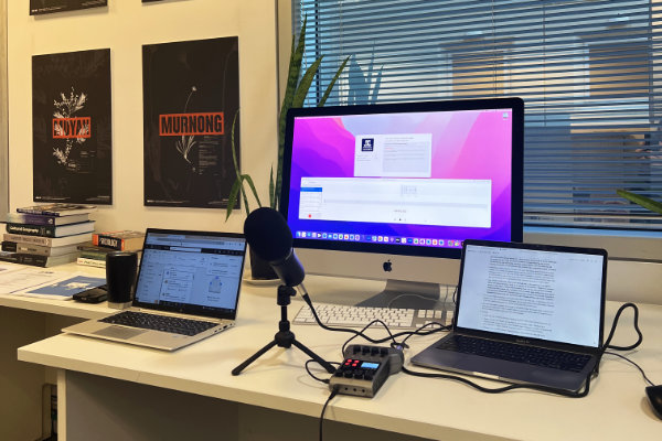 Desk with computer monitor, microphone and podcasting equipment