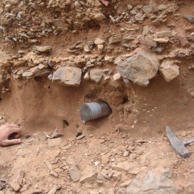 Core sample protruding from red rock.