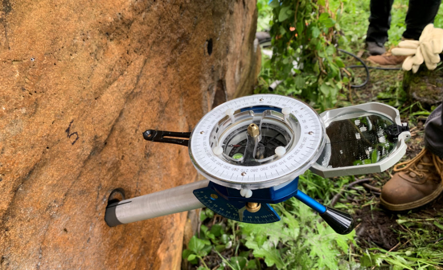 Orientation tool with probe inserted into hold drilled in rock