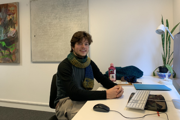 Timothy Rzesniowiecki sitting at a desk in office.