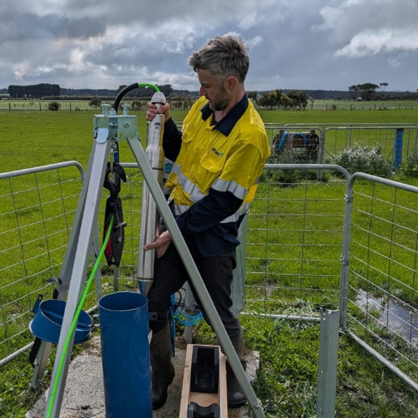 Seismologist removing instrument from borehole