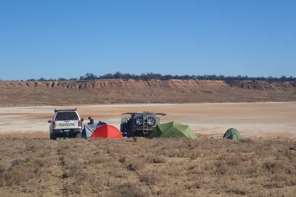Campsite on a dry grassland with a raised plateau in the background.