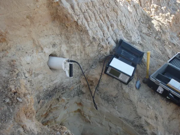 Instrumentation on rock connected to a probe inserted into a bored hole.